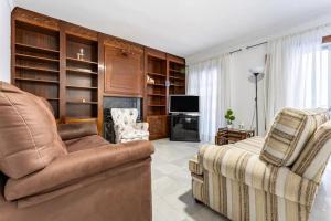 sala de estar con sofá y silla en Casa capitán en Fuengirola