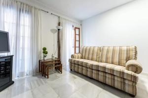 a living room with a couch and a television at Casa capitán in Fuengirola +10 photos