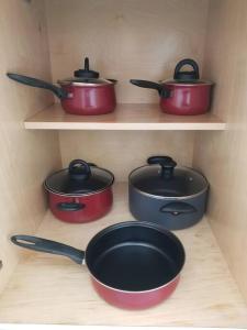 four pots and pans on shelves in a kitchen at My lovely home in Miami 15 minutes from the Beach in Miami