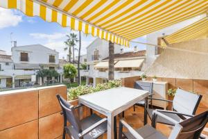 d'une terrasse avec une table et des chaises sur un balcon. dans l'établissement Tu casita de la playa, à Santa Pola