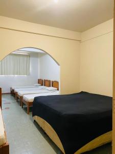 uma fila de camas num quarto com um arco em Hotel Cristal em Rondonópolis