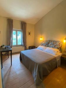 a bedroom with a large bed and a table at Locanda Granducato in Chiusi