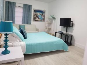 1 dormitorio con cama, sofá y TV en My lovely home in Miami 15 minutes from the Beach, en Miami