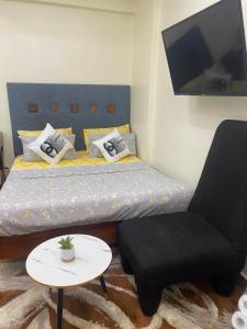a small bedroom with a bed and a chair at Apartment with beautiful view, free wifi, swimming pool and gym in Dar es Salaam
