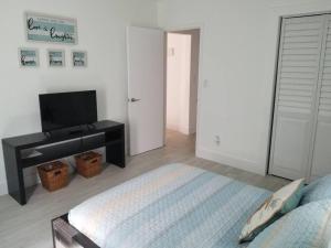 a bedroom with a bed and a desk and a television at My lovely home in Miami 15 minutes from the Beach in Miami