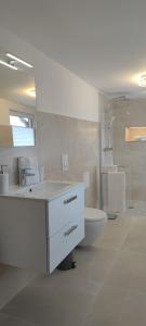 a white bathroom with a sink and a toilet at Ferienhaus Harztörchen in Halberstadt