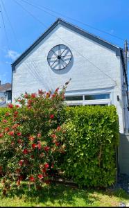 uma casa com um relógio ao lado dela em The Old Workshop - Drift em Penzance