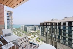 a balcony with chairs and a view of a building at Prime 3BR Suite in Bluewaters - Full Ain Dubai View - Livbnb in Dubai