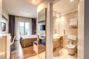 a hotel room with a bed and a bathroom at Hotel Isola Sacra Rome Airport in Fiumicino