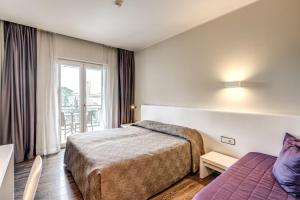 a hotel room with a bed and a window at Hotel Isola Sacra Rome Airport in Fiumicino
