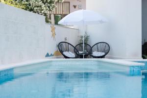 twee stoelen en een parasol naast een zwembad bij Apartments Niko in Makarska