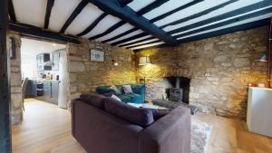 a living room with a couch and a stone wall at Bushnells Cottage in Oxford