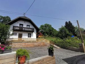 una casa blanca con techo negro y algunas plantas en Lendorfer Cottage, en Feldkirchen in Kärnten