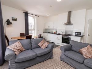 a living room with two couches and a kitchen at 7 Beach View Beaconsfield House in Bridlington