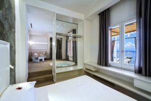 a bedroom with a large window and a bed and a tub at La Sciabica in Agropoli