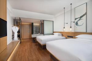 Baiyin的住宿－白银万枫酒店，酒店客房设有两张床和盥洗盆
