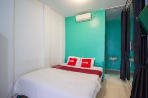 a bedroom with a white bed with red pillows at Halona Residence near Pakuwon Mall Jogja Mitra RedDoorz in Yogyakarta