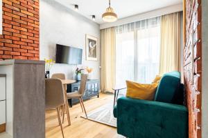 a living room with a green couch and a table at ApartamentySnu, Wola Premium II z parkingiem in Warsaw