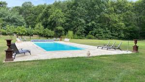 a swimming pool with two chairs next to at Domaine de Charnay Villégiature Sologne in Vierzon