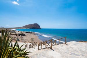 a stairway leading down to a beach with the ocean at MEDANO4YOU Hello Beach! Holiday Home in La Tejita