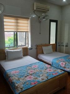 twee bedden naast elkaar in een slaapkamer bij Hotel Thanh Bình 2 in Ha Tinh