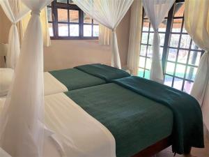 Un pat sau paturi într-o cameră la Twin bed lodge on natural African bush - 2111