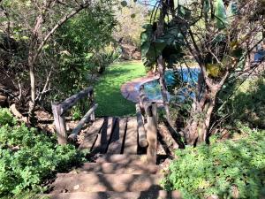 una escalera de madera que conduce a un camino con árboles en Twin bed lodge on natural African bush - 2111, en Bulawayo
