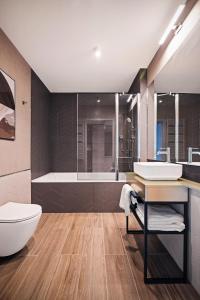łazienka z toaletą, umywalką i wanną w obiekcie Royal Apartments - Boutique Residence Gdańsk w Gdańsku