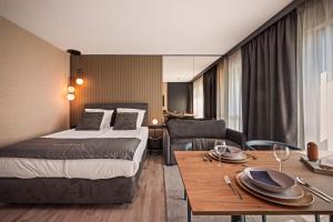 a hotel room with a bed and a dining table at Boutique Residence Gdańsk in Gdańsk