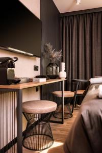 une chambre d'hôtel avec un bureau et deux tabourets dans l'établissement Royal Apartments - Boutique Residence Gdańsk, à Gdańsk