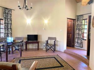 a living room with a couch and a table and a desk at Double lodge on natural African bush - 2112 in Bulawayo