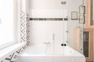 a white bathroom with a tub and a shower at Venus Apartments - Market Hall I in Budapest