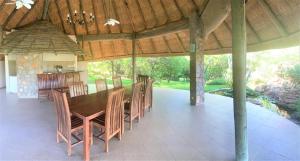a dining room with a wooden table and chairs at Double lodge on natural African bush - 2112 in Bulawayo