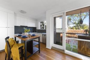 a kitchen with a table and a dining room at Beachside Getaway on Selwyn in Melbourne