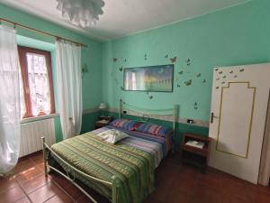 a bedroom with a bed in a room with green walls at Primula by Villa Very in Marina di Campo