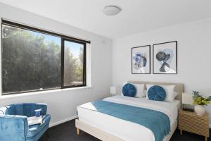 a bedroom with a bed and a large window at Beachside Getaway on Selwyn in Melbourne