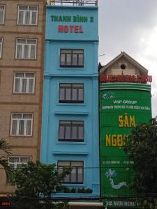 un bâtiment bleu avec un panneau indiquant un hôtel dans l'établissement Hotel Thanh Bình 2, à Hà Tĩnh