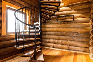 a spiral staircase in a log cabin with a window at Hotel Paradise in Sukhum