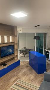 ein Wohnzimmer mit einem blauen Tisch und einem TV in der Unterkunft Estanconfor Santos 705 com estacionamento GRÁTIS in Santos