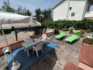 a patio with a table and chairs and an umbrella at Primula by Villa Very in Marina di Campo