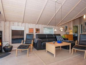 a living room with a couch and chairs and a table at 8 person holiday home in Hemmet in Falen