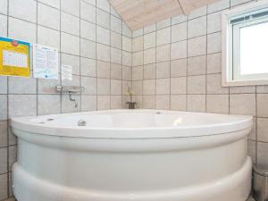 baño con bañera blanca y ventana en 8 person holiday home in Hemmet, en Falen