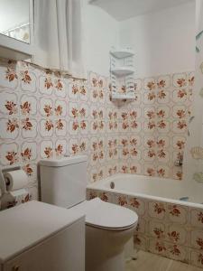 a bathroom with a toilet and a bath tub at Sunshine Apartment in Preveza