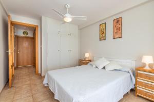 プラヤ・デアロにあるSun Towerの白いベッドルーム(ベッド1台、天井ファン付)