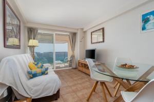 a living room with a glass table and a dining room at Sun Tower in Platja  d'Aro