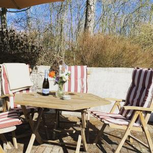 a picnic table with two chairs and a bottle of wine at Rebild Skovhuse in Skorping