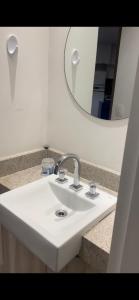 Estanconfor Santos 705 com estacionamento GRÁTIS في سانتوس: بالوعة بيضاء في الحمام مع مرآة
