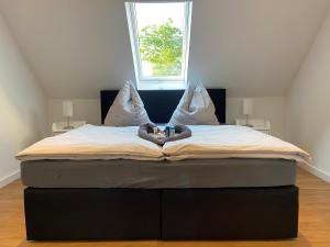 ein großes Bett in einem Zimmer mit Fenster in der Unterkunft Entspannungsoase Steinhuder Meer inklusiv Sauna und WLAN in Neustadt am Rübenberge