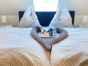 Bett mit einem Tablett mit Produkten darauf in der Unterkunft Entspannungsoase Steinhuder Meer inklusiv Sauna und WLAN in Neustadt am Rübenberge