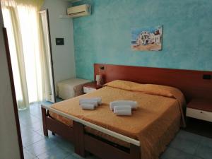 ein Schlafzimmer mit einem Bett mit zwei Handtüchern darauf in der Unterkunft Megaron Hotel in Pozzallo